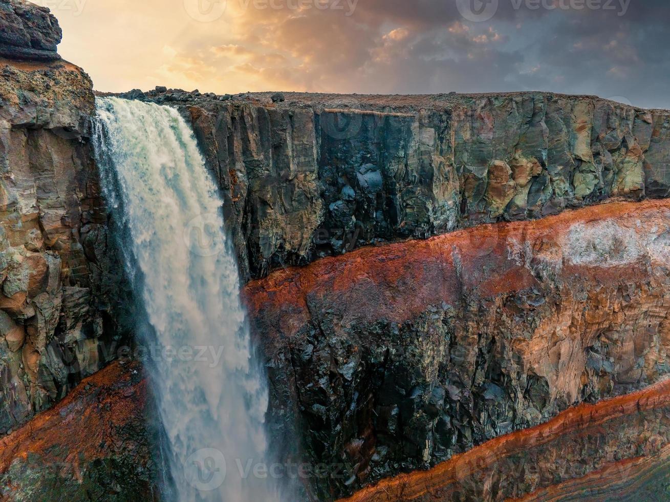 vista aérea de la cascada hengifoss con sedimentos de rayas rojas en islandia. foto