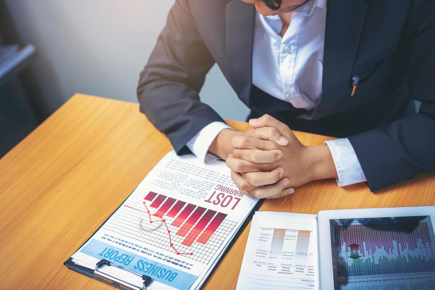 Bad investment or economic crisis concept. Crop image of businessman's hands holding from business disappointed and seriously by bad business results report. Selected focus. photo