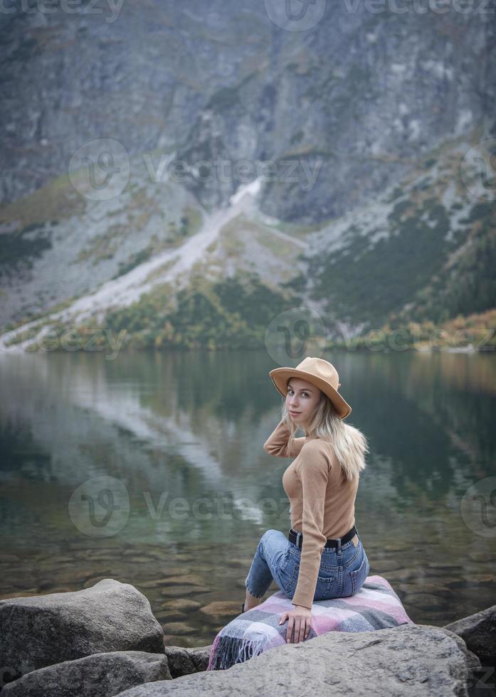 Young woman on a hiking trip sitting on a rock photo