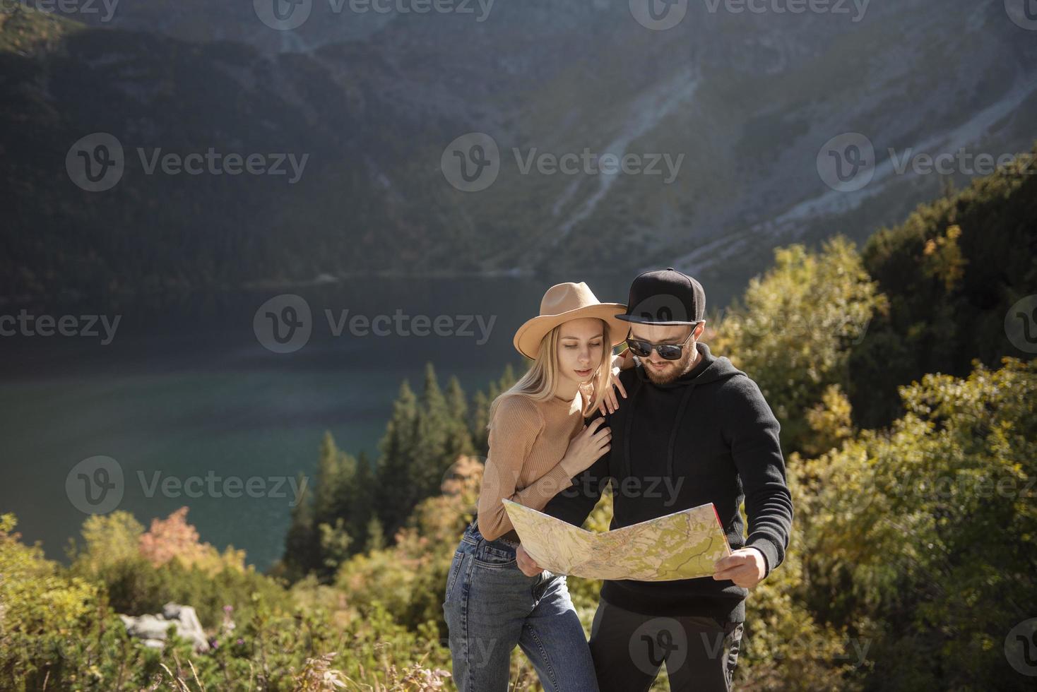 Young tourist couple, man and woman, on hiking path in mountains photo