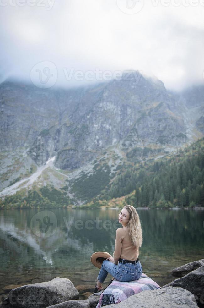 Young woman on a hiking trip sitting on a rock photo