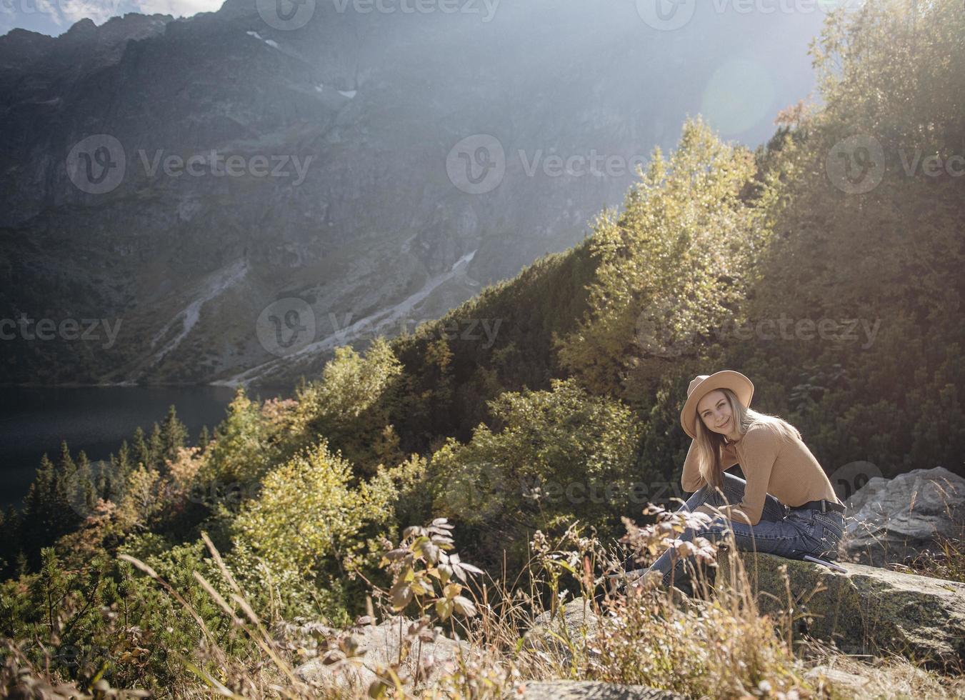 Young woman on a hiking trip sitting on a rock photo