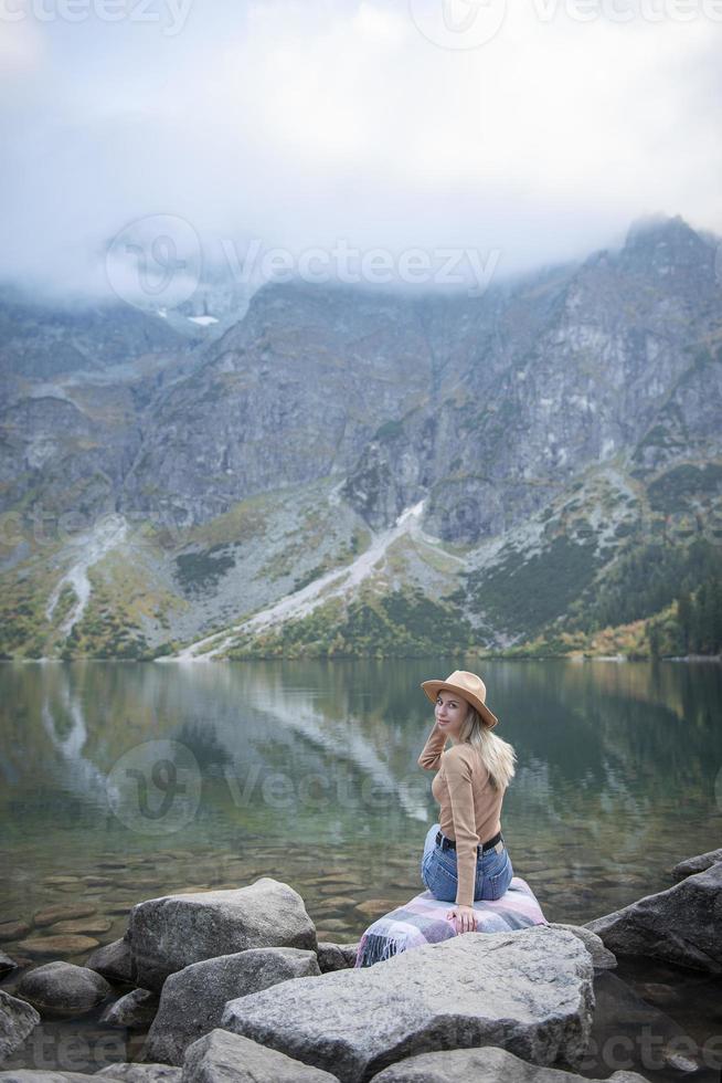 Young woman on a hiking trip sitting on a rock photo