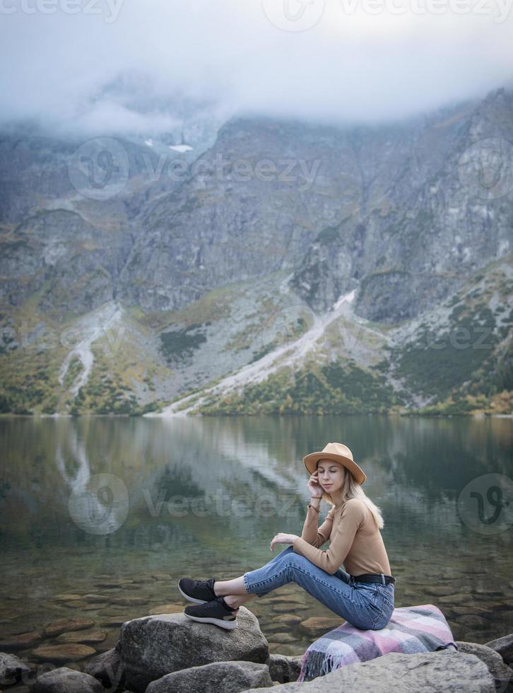 Young woman on a hiking trip sitting on a rock photo