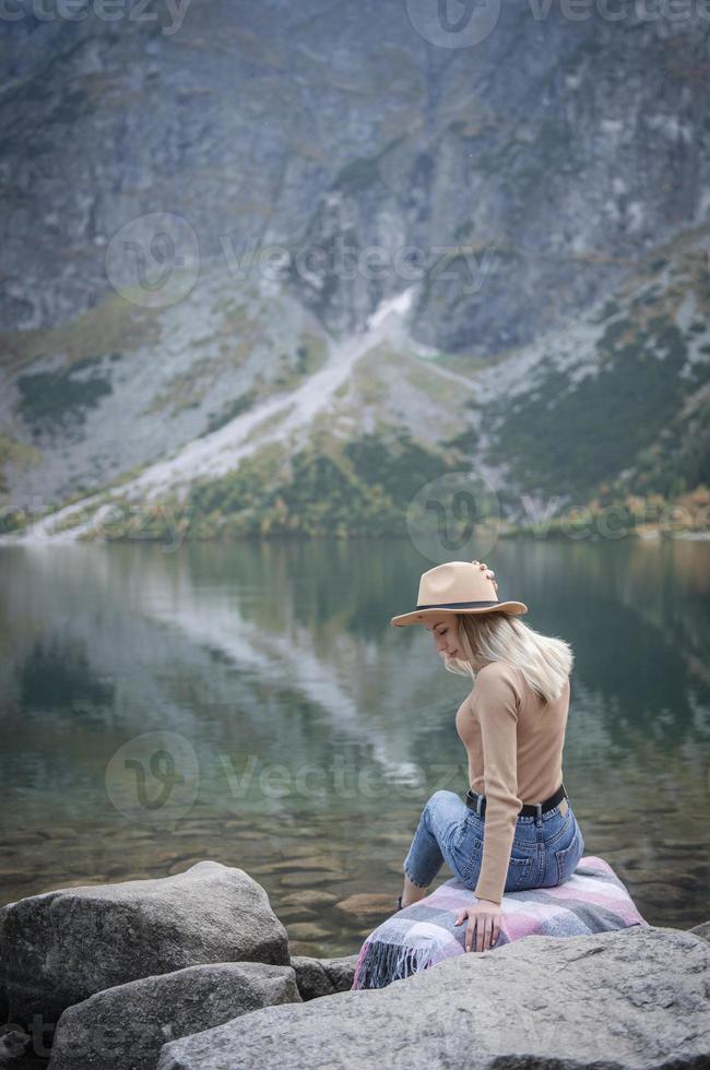 Young woman on a hiking trip sitting on a rock photo