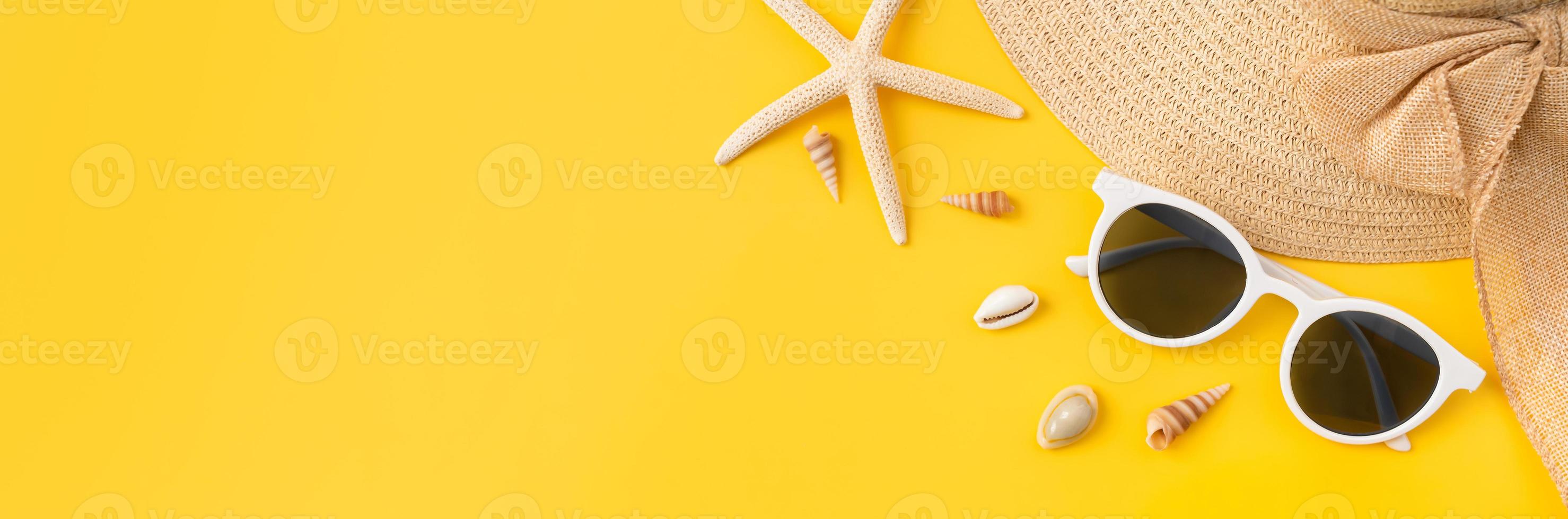 concepto de horario de verano, vista superior con espacio de copia de gafas de sol y sombrero con estrellas de mar sobre fondo amarillo. foto