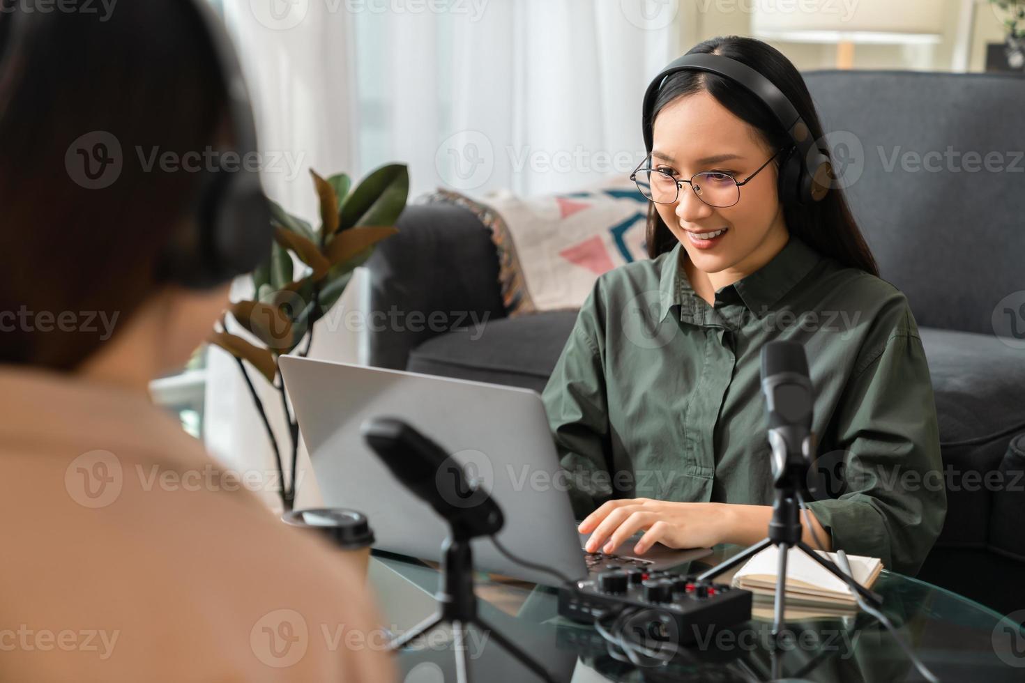 una joven asiática usa micrófonos, usa auriculares con una computadora portátil, graba una entrevista de podcast para la radio. concepto de creador de contenido. foto