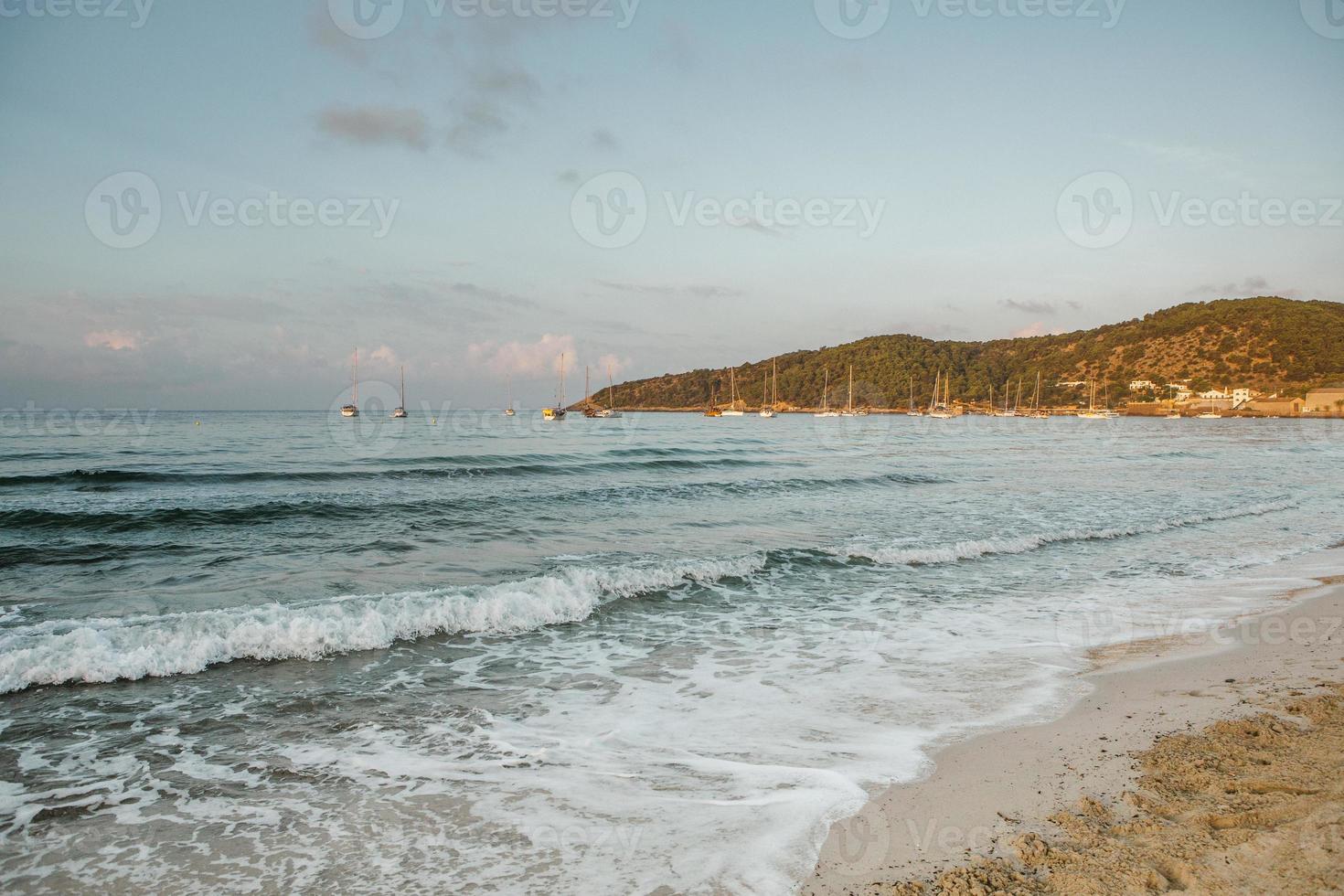 Beautiful beach with very clean and azure water on the mediterranean sea in the island of Ibiza, Spain. photo
