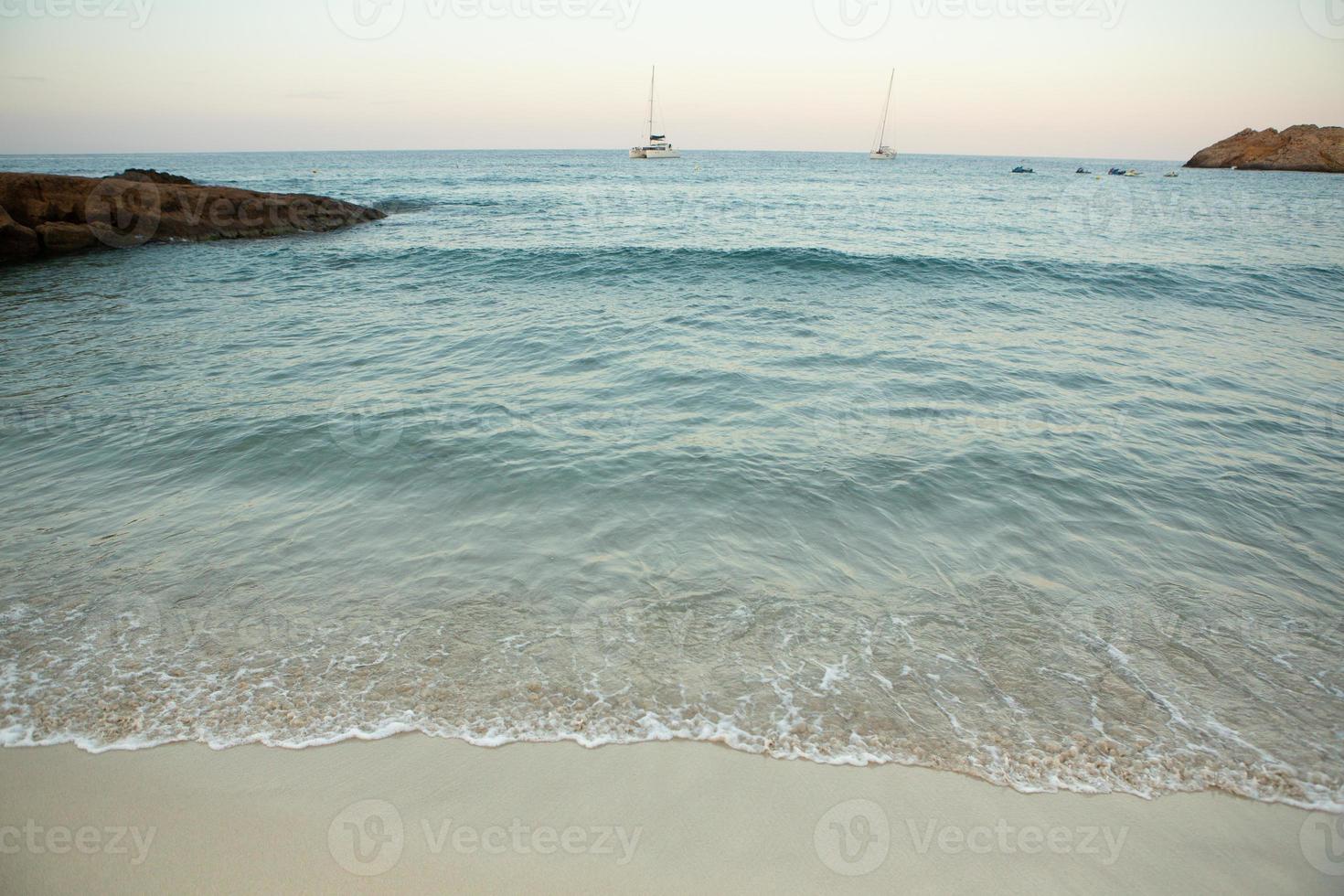 Beautiful beach with very clean and azure water on the mediterranean sea in the island of Ibiza, Spain. photo