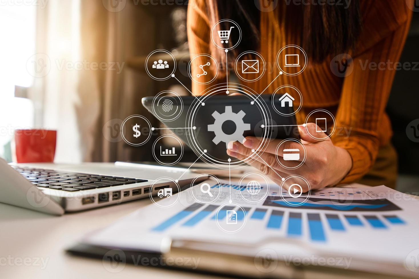 Hands using mobile phone in modern office with laptop photo