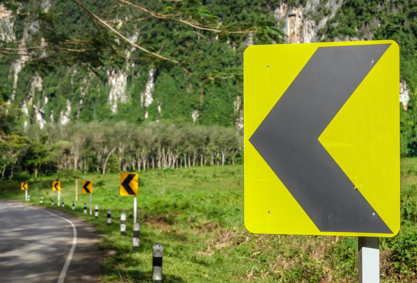 Left curve road warning traffic sign made by solar energy that can visible in night time, leads people to destinations by safety. photo