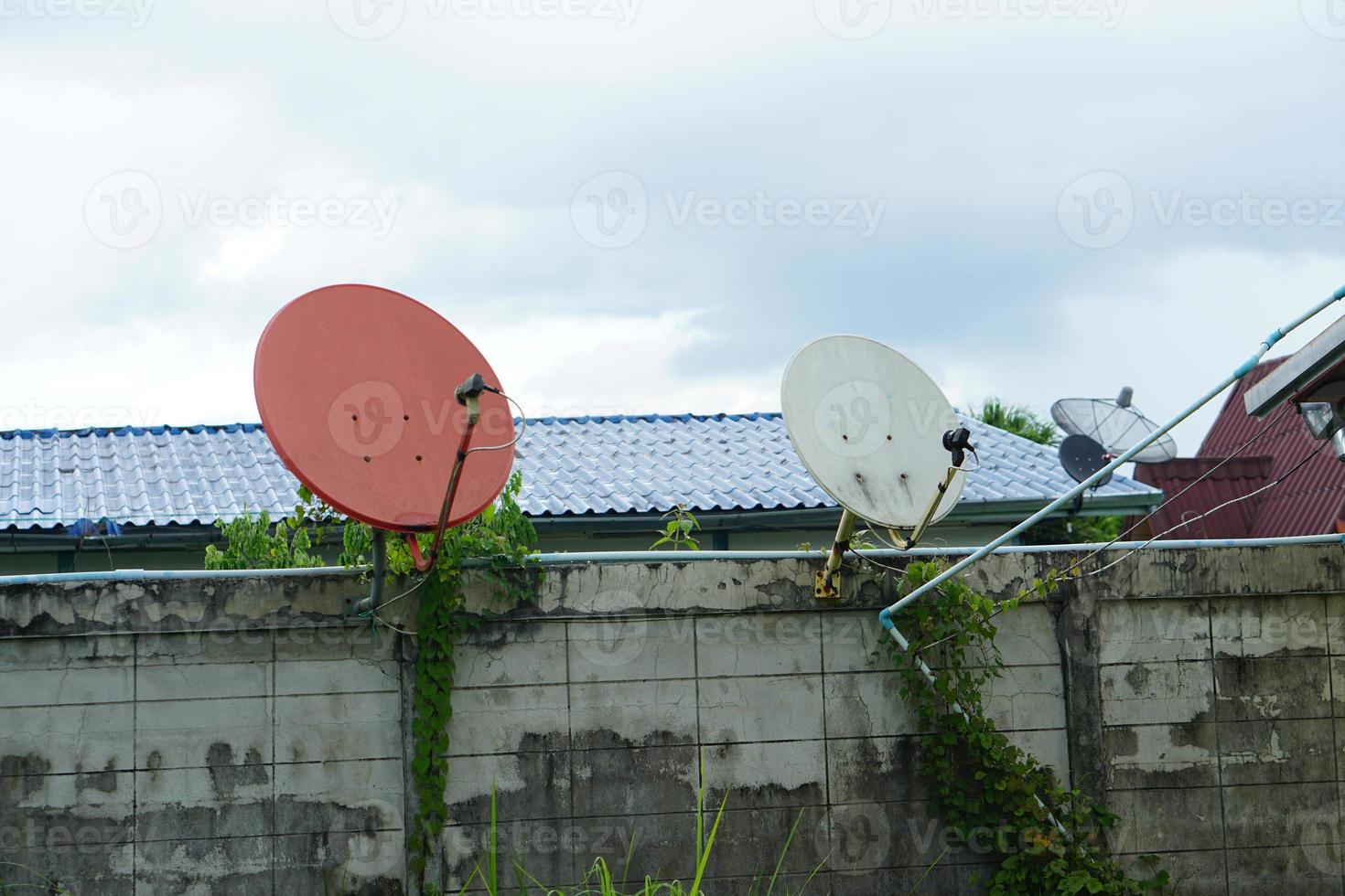 Orange satellite dish dish for receiving TV signals Attached to the roof of the house In order to be in a high place and open to receive signals well photo