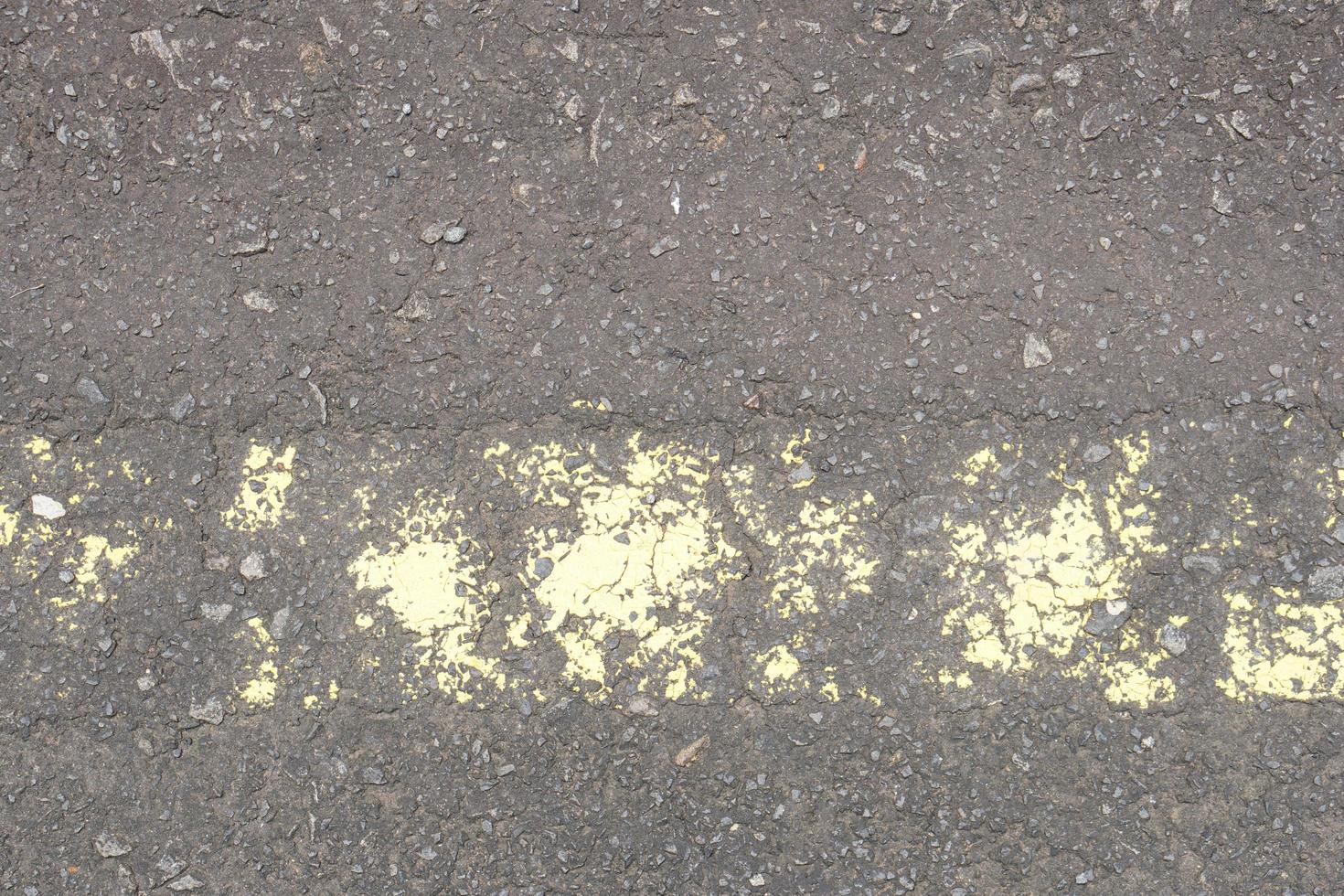 old road surface has yellow lines peeling off. photo