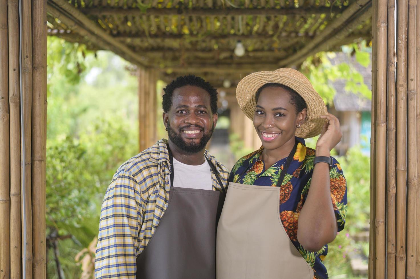 feliz pareja de agrónomos negros disfrutando y trabajando en tierras de cultivo, concepto de agricultura foto