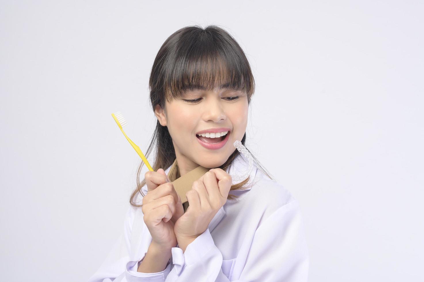 Young female dentist smiling over white background studio photo