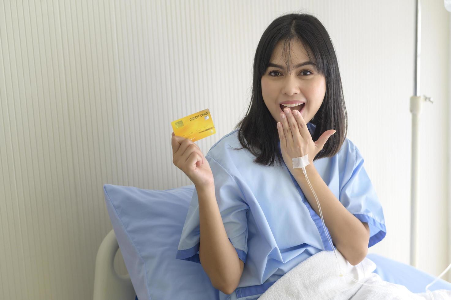 A young patient woman is holding credit card , admitting in hospital , Health care  concept photo