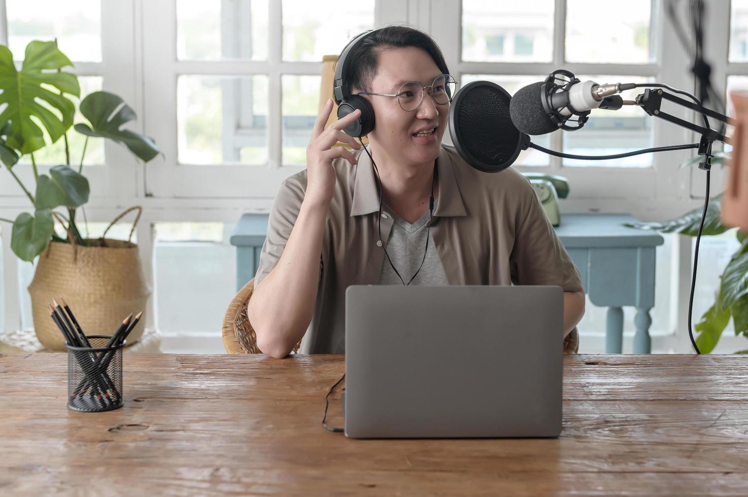 An asian man is using microphone podcasting in home photo