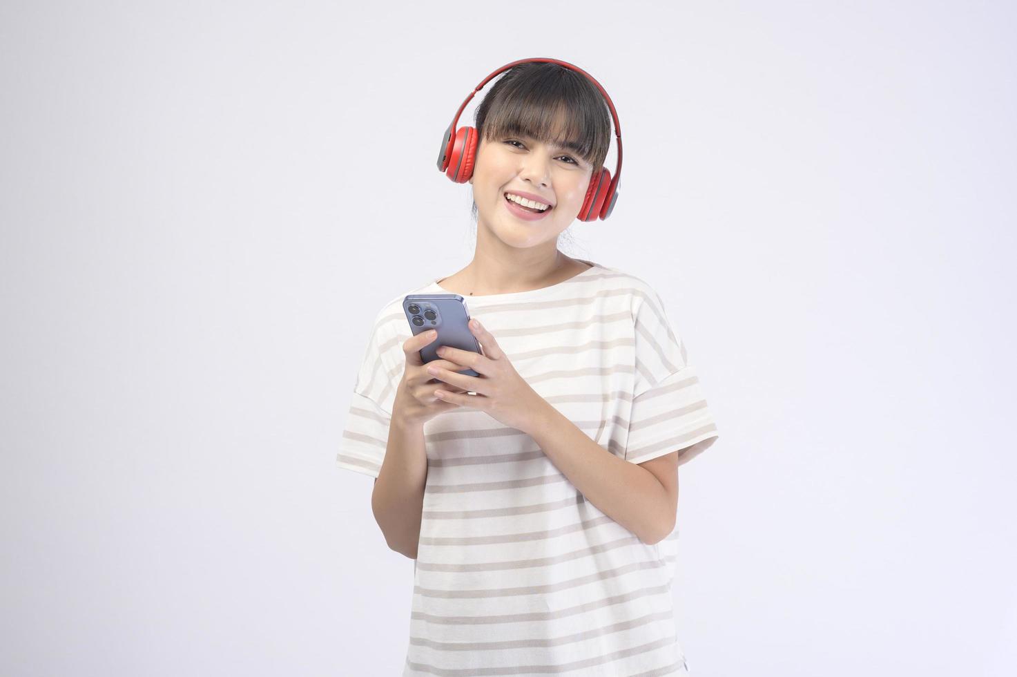 Hermosa mujer joven con auriculares sobre fondo blanco. foto