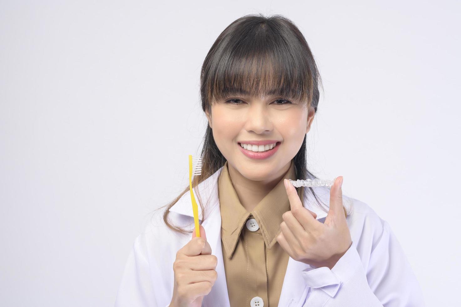 Young female dentist smiling over white background studio photo