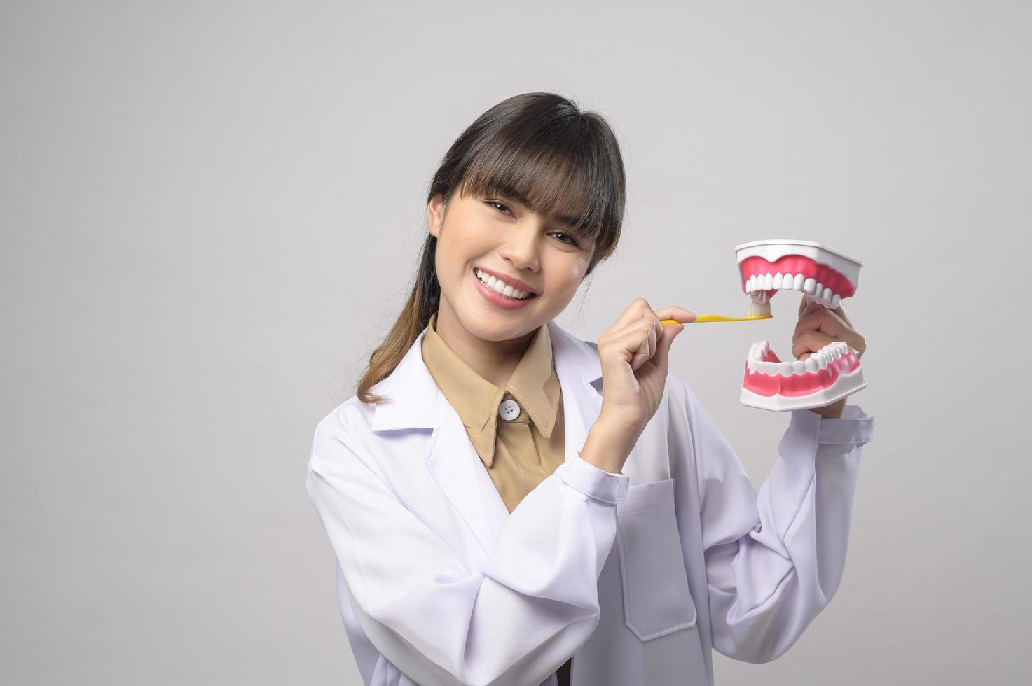 Young female dentist smiling over white background studio photo