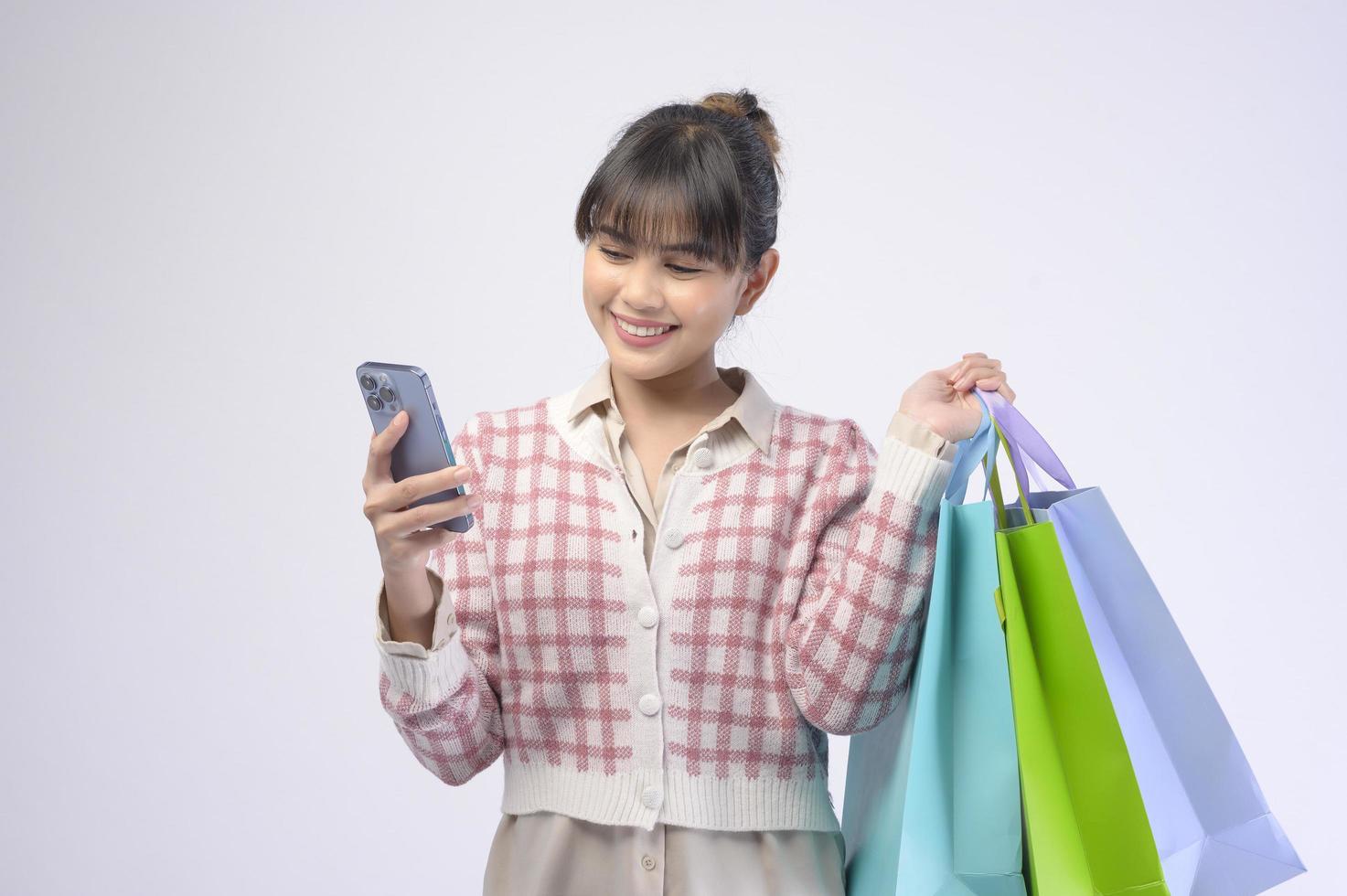 Attractive shopper woman holding shopping bags over white background photo