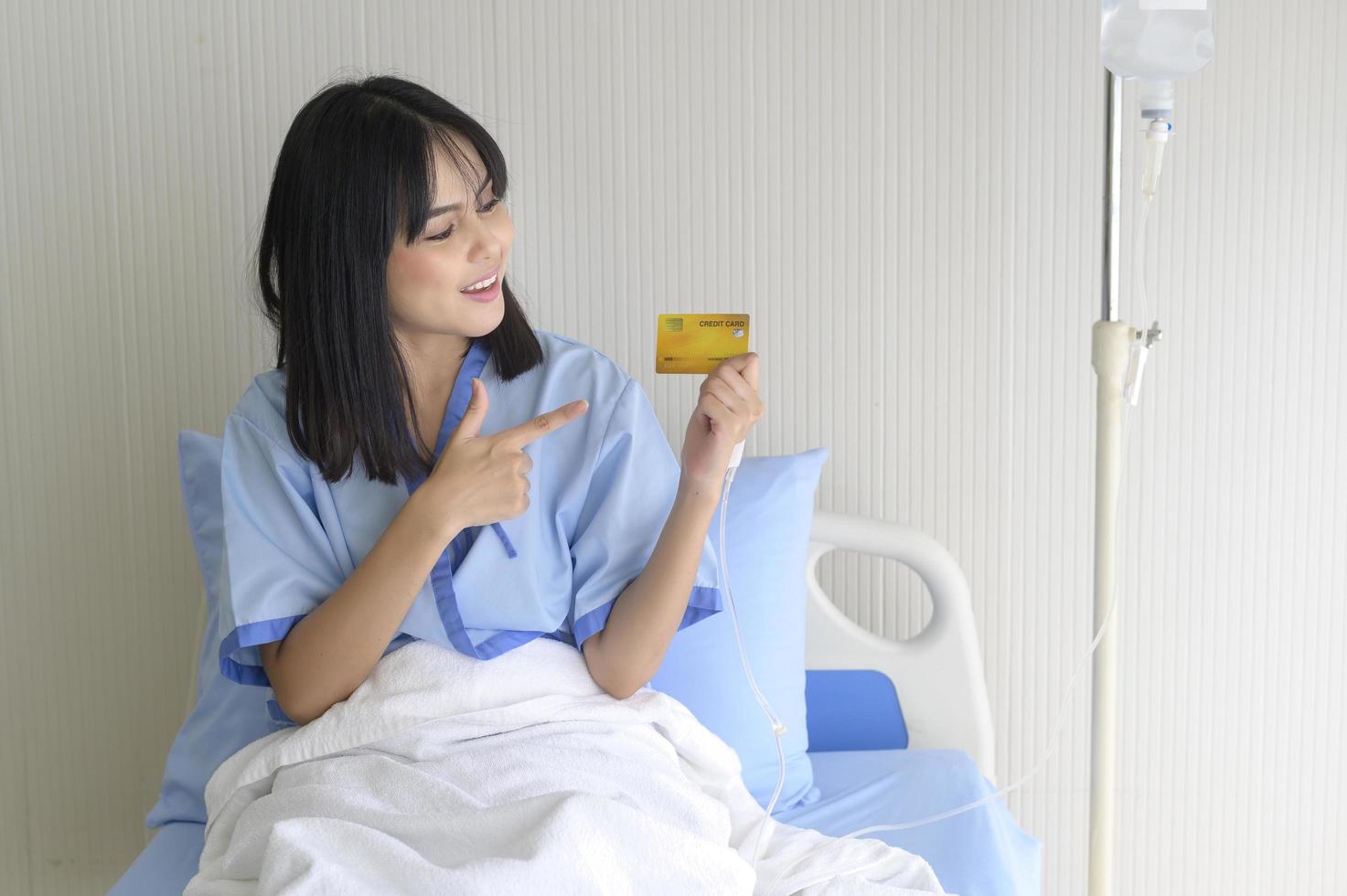A young patient woman is holding credit card , admitting in hospital , Health care  concept photo