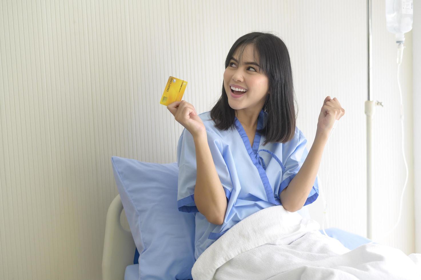 A young patient woman is holding credit card , admitting in hospital , Health care  concept photo