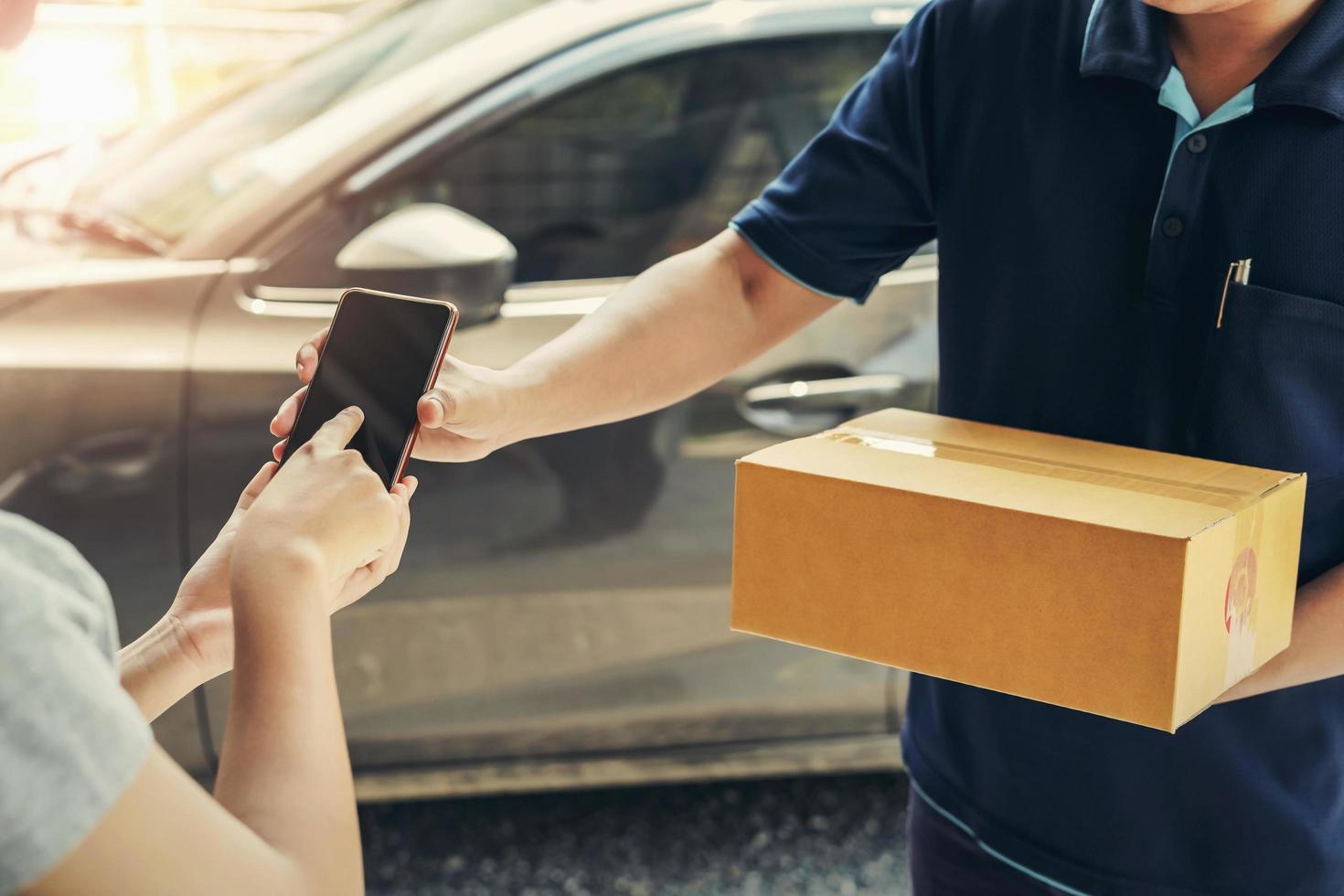 woman hand appending signature in mobile phone for receiving parcel photo