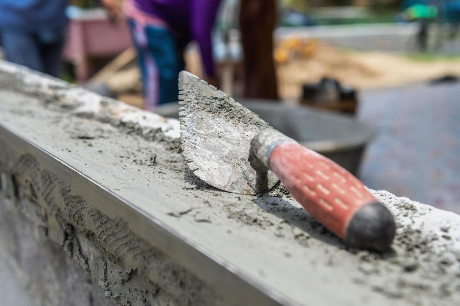 trowel on cement in construction site photo