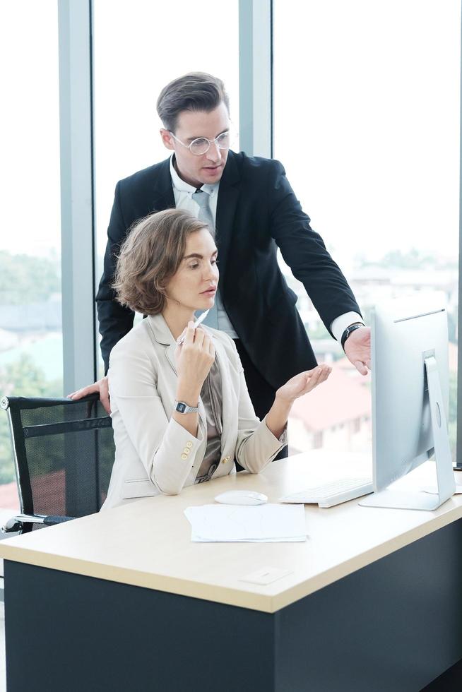 Successful businessman and businesswoman working and share ideas at office computor desk photo