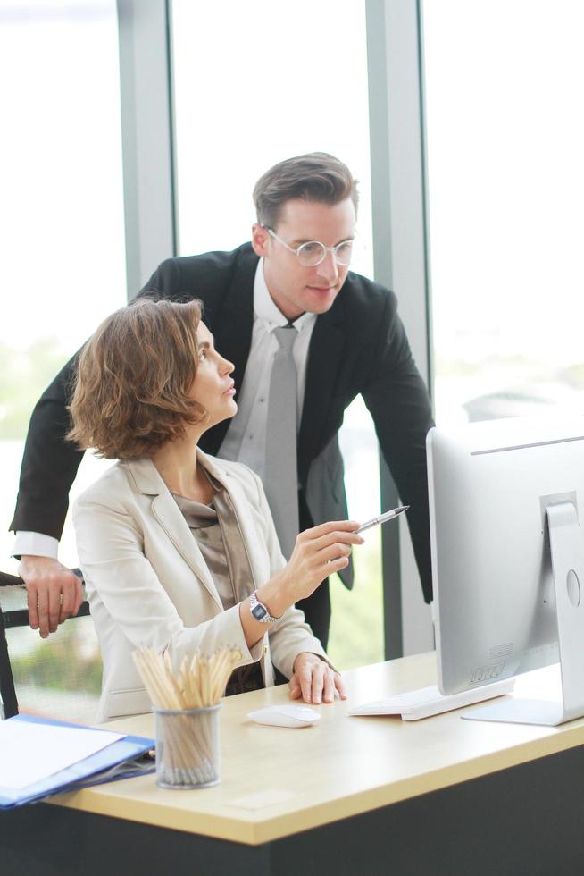 Successful businessman and businesswoman working and share ideas at office computor desk photo