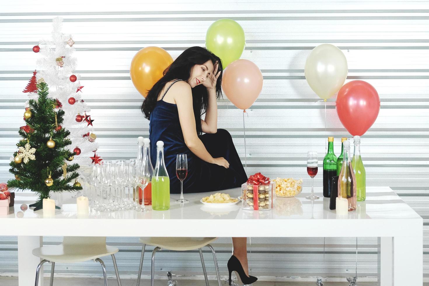 Beautiful Caucasian woman drinking wine in christmas time and celebrating new year eve party and happiness with colorful balloon and Gift Boxes at pantry area. photo