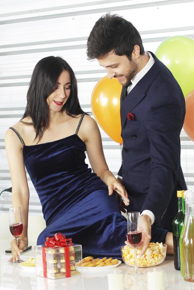 Sweet couple Love smile and spending Romantic with drinking wine in christmas time and celebrating new year eve, valentine day with colorful balloon and Gift Boxes at pantry area photo