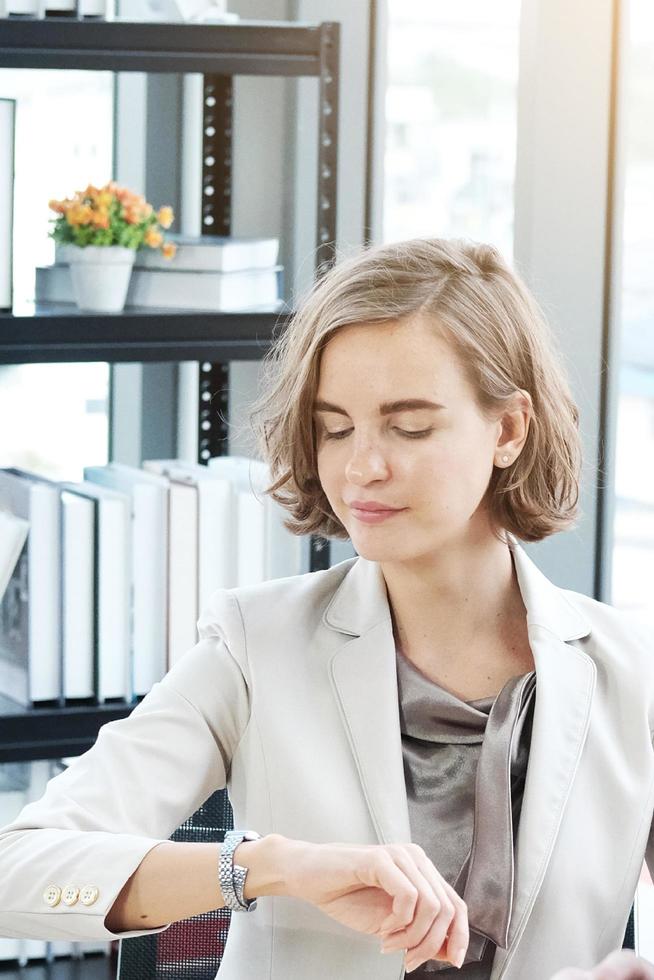 Businesswoman in white suit Watch wristwatch and  serious about important Time for to late and delay photo