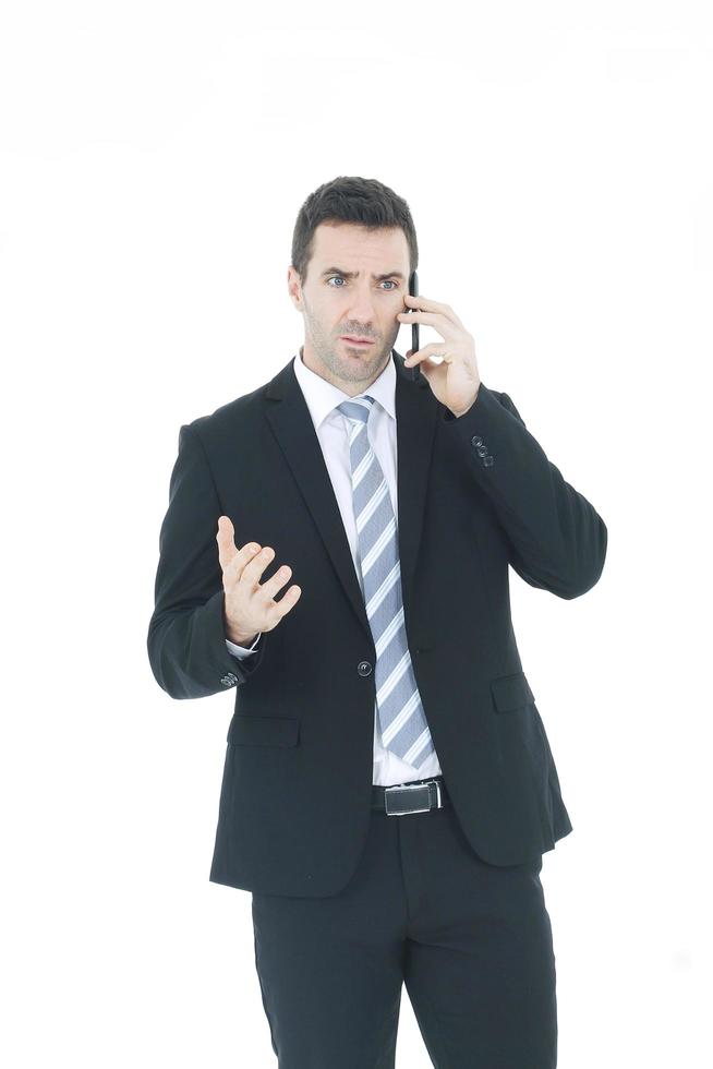 apuesto hombre de negocios en una mano de traje sosteniendo un teléfono inteligente y hablando por teléfono aislado en fondo blanco. copie el espacio foto