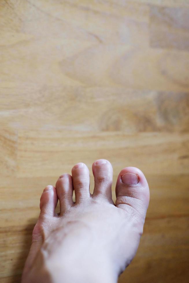 Closed up female feet with french nails on wood floor, Healthy care and medical concept photo