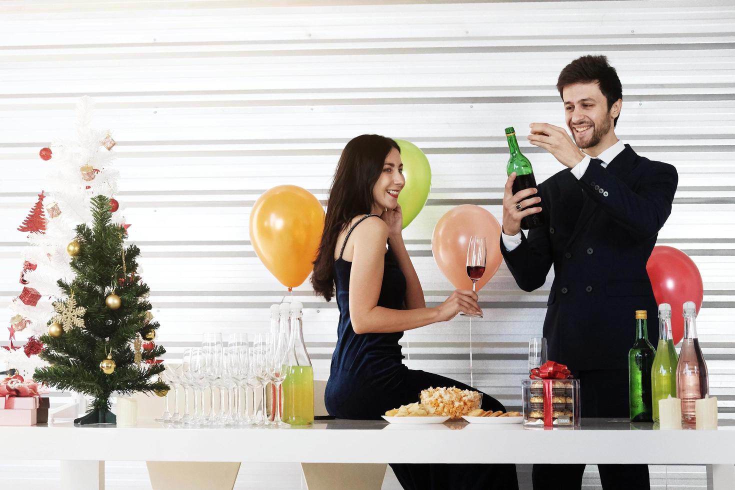 Sweet couple Love smile and spending Romantic with drinking wine in christmas time and celebrating new year eve, valentine day with colorful balloon and Gift Boxes at pantry area photo