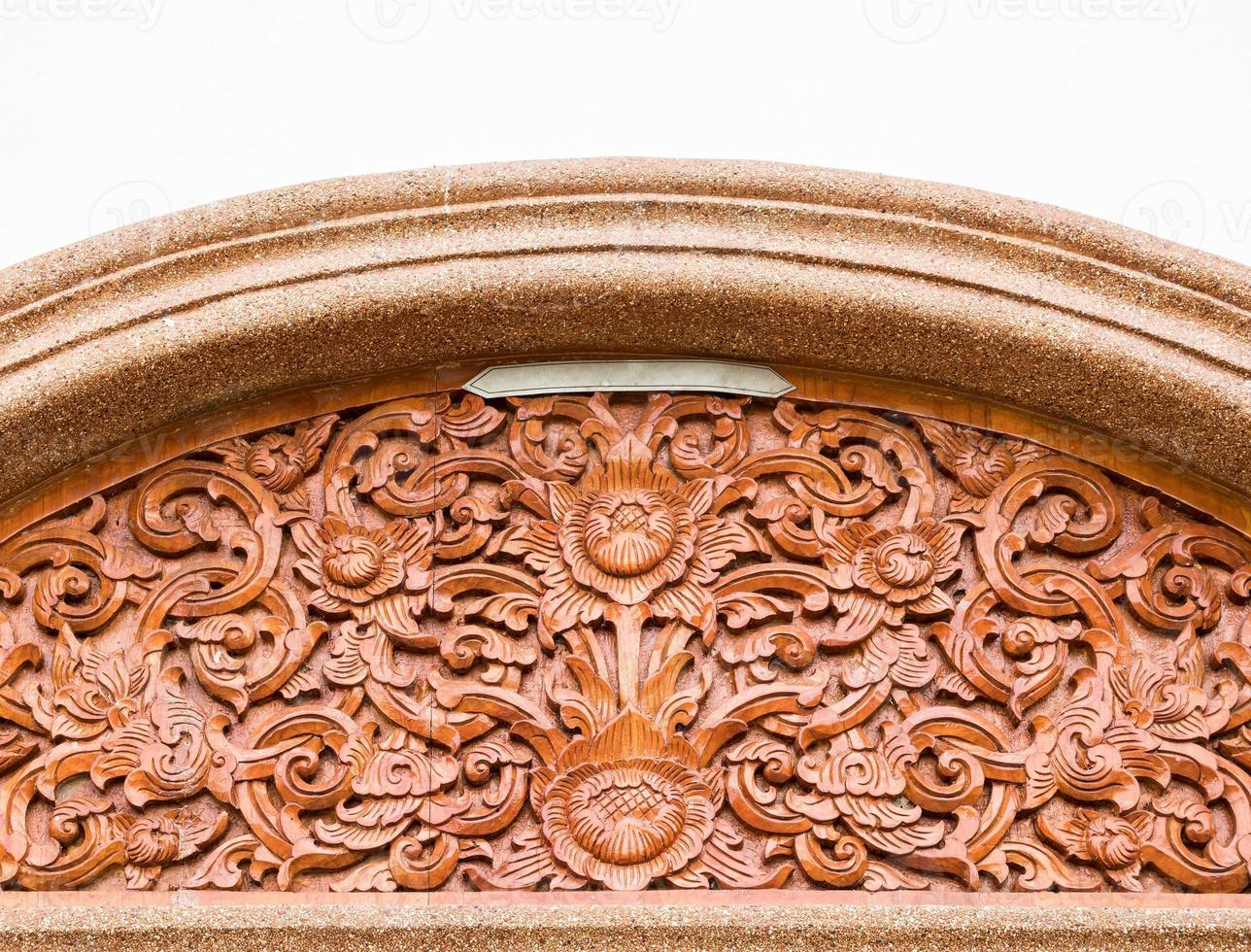 Carved lotus pattern in the traditional Thai style on the wood. photo