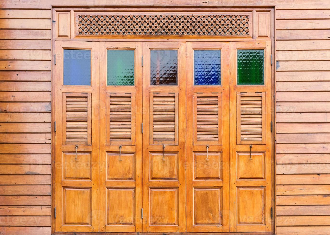 Complex wooden window with the colorful glass. photo