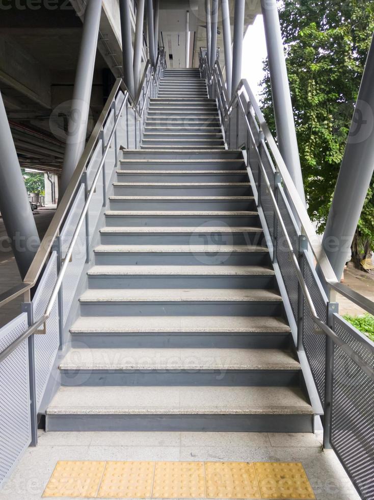 The empty modern staircase with the metal railing for entrance to the commuter train station. photo