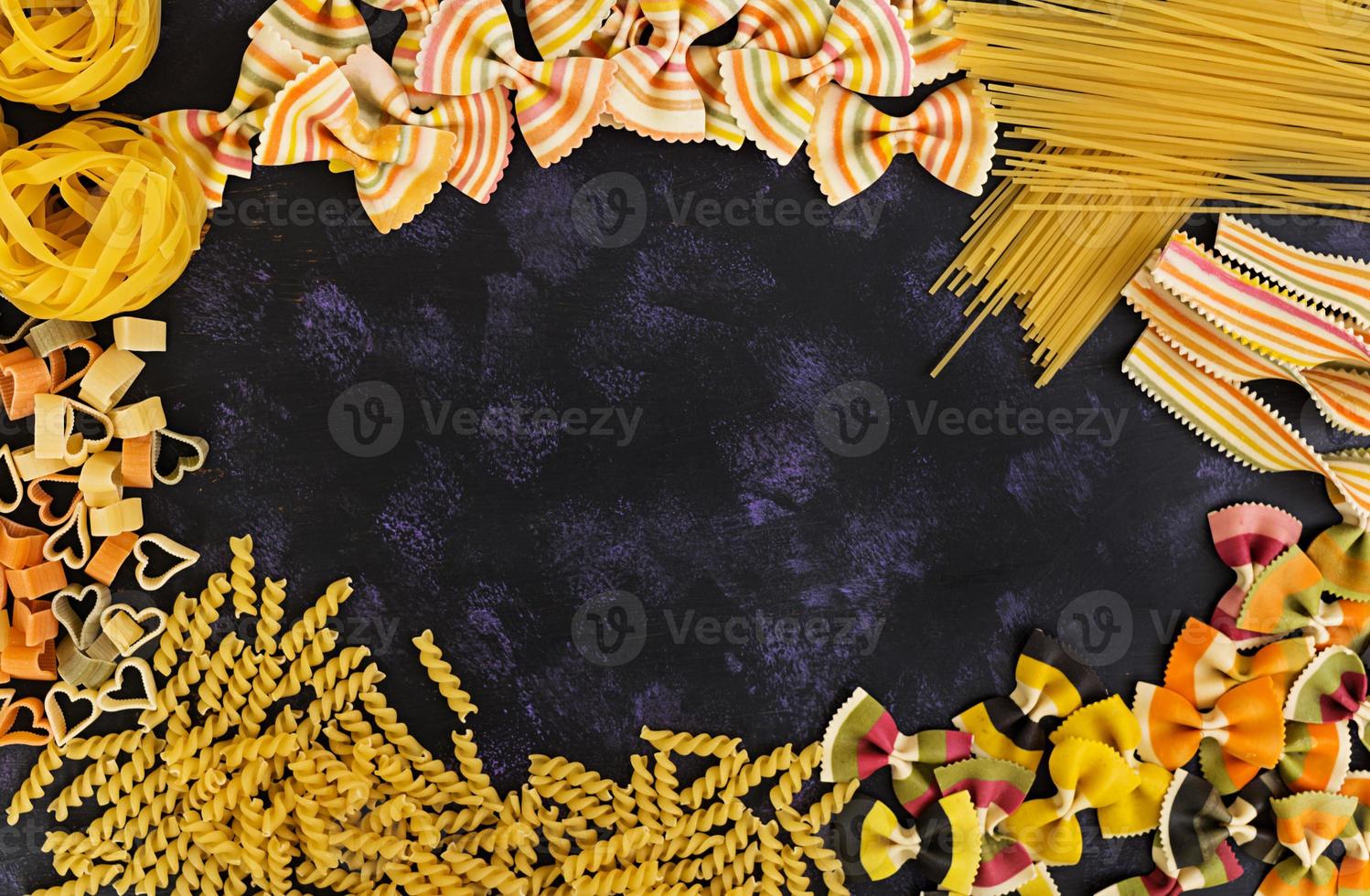 Dry pasta background. Different pasta on dark background. Flat lay. Top view. photo