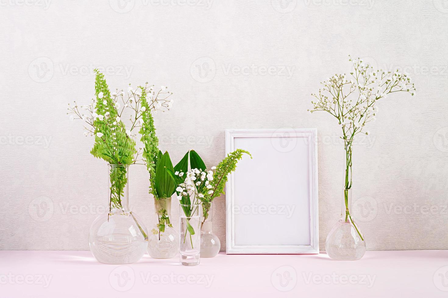 Flowers and plants in flask with frame. Beautiful spring background with flowers in vase. photo