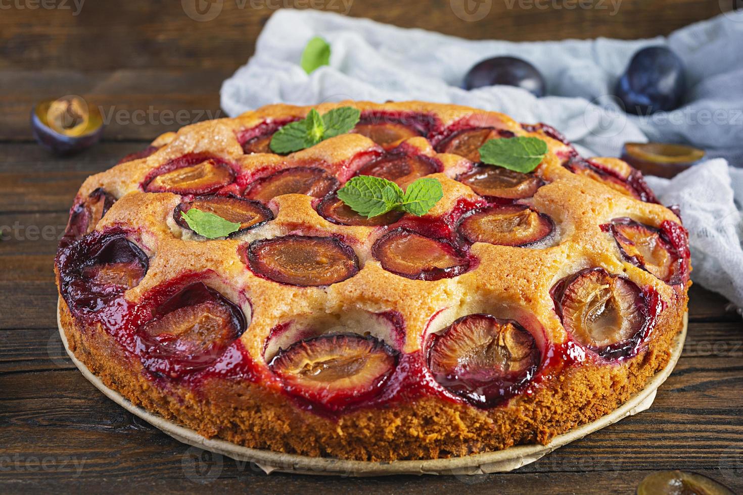 Delicious homemade plum pie on rustic background photo