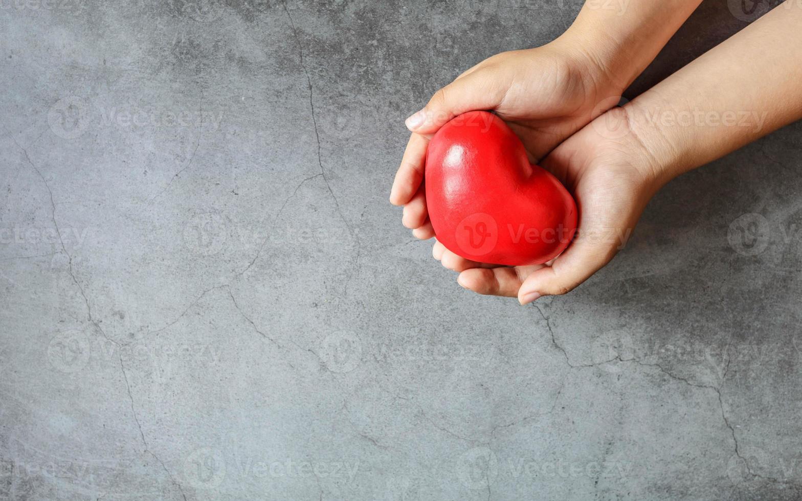 corazón en la mano dando el concepto de donación de corazón. foto