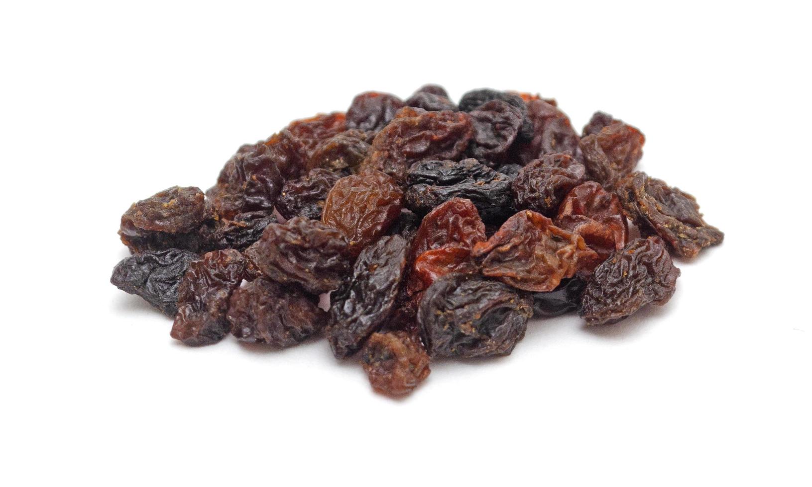 pile of dark raisins isolated on white background photo