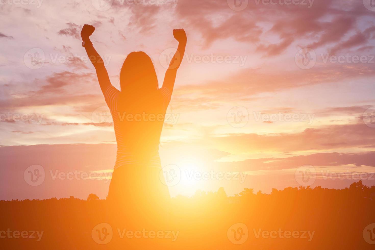 Silhouette of woman praying over beautiful sky background photo
