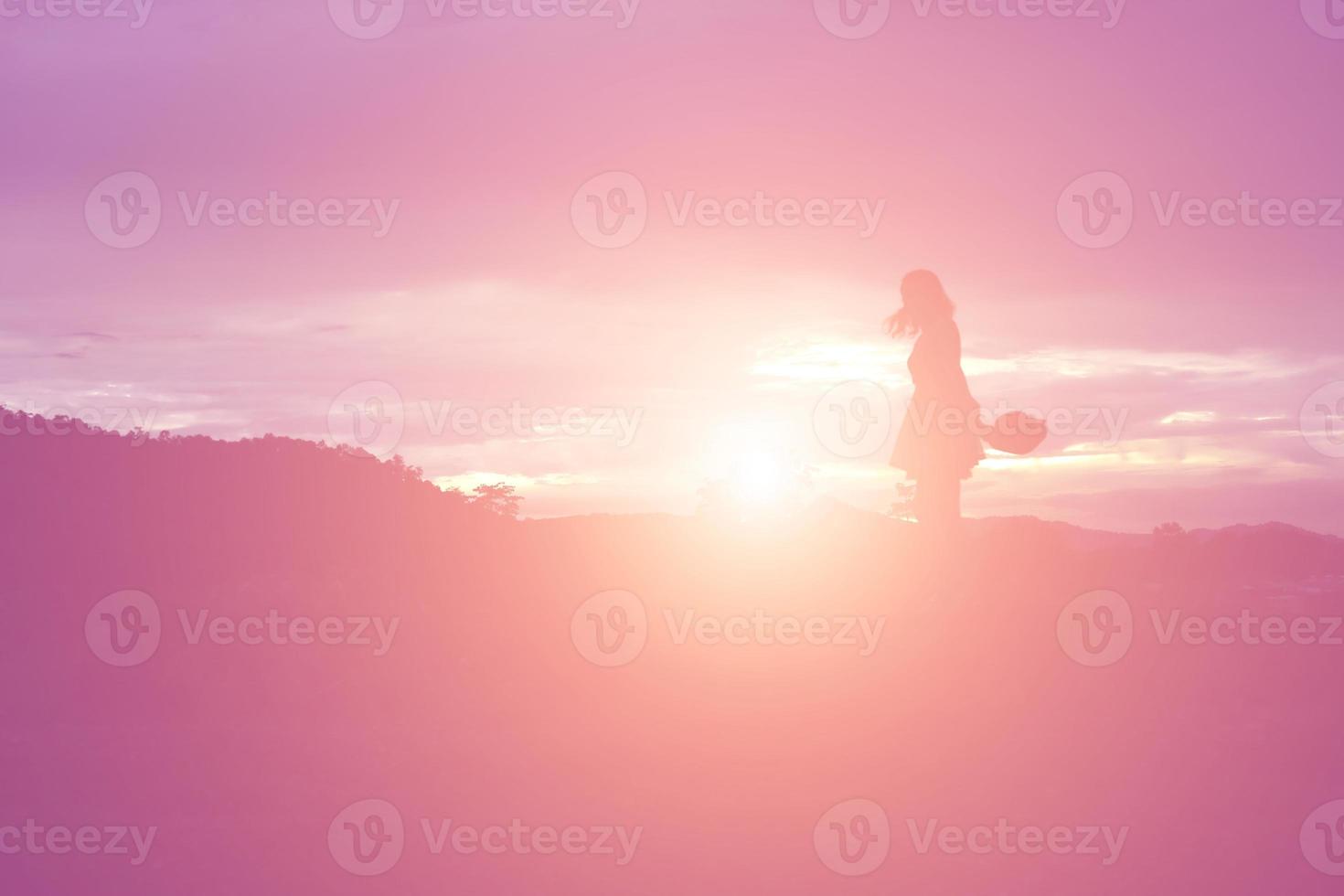 Silhouette of woman praying over beautiful sky background photo
