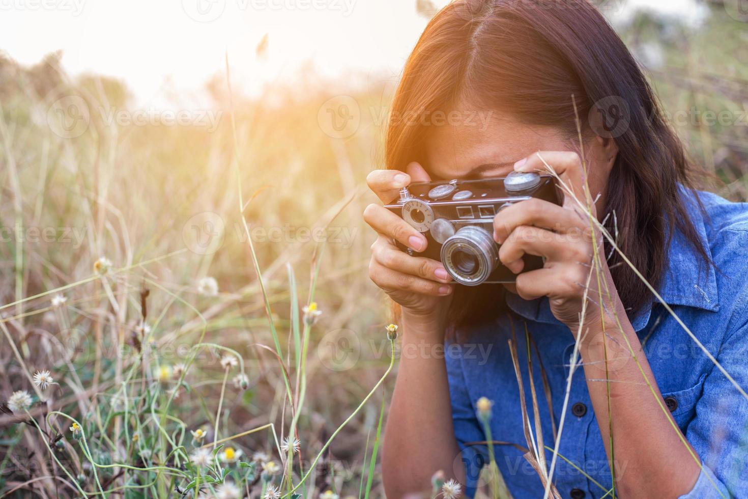 vintage de fotografía de mujeres hermosas mano de pie sosteniendo cámara retro con amanecer, estilo suave de ensueño foto