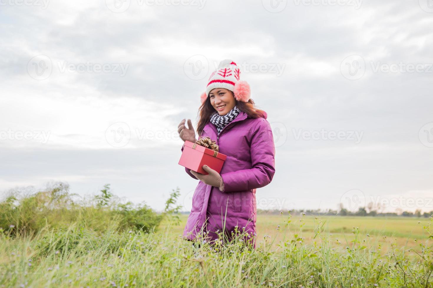 Happy young woman with gift in hands. Christmas and winter concept. photo