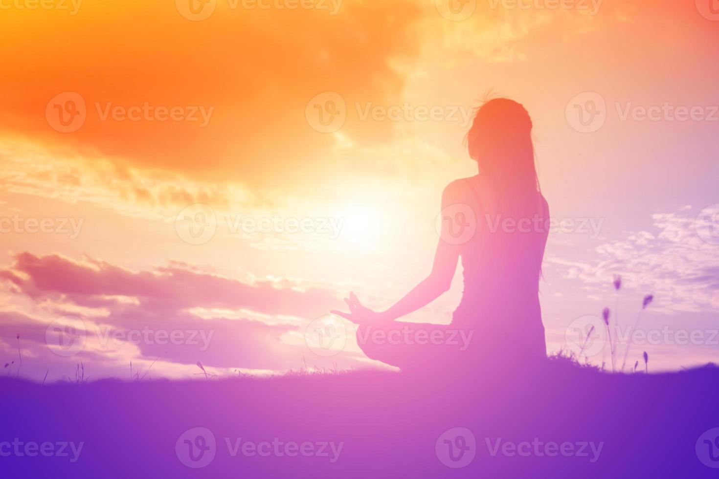 Silhouette of woman praying over beautiful sky background photo